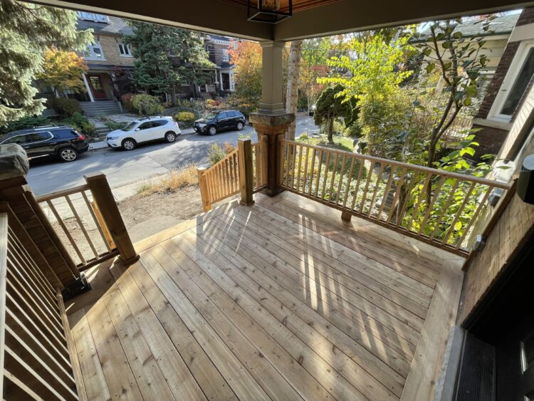 Wooden deck under construction with visible beams and supports in a backyard setting.