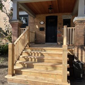 Elegant wooden stairs on a front porch with a welcoming entryway, ideal for greeting visitors.