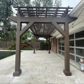 backyard with a dark brown pergola over a paved patio next to a swimming pool