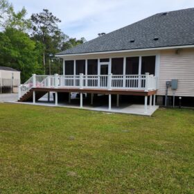 Spacious suburban deck with white railings and a large backyard, ideal for family activities.