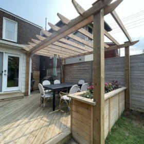 Wooden pergola over a backyard dining area with stylish outdoor furniture