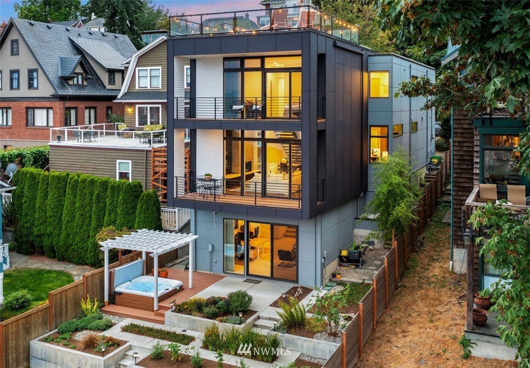 Contemporary multi-level home with floor-to-ceiling windows, rooftop deck, and landscaped backyard.