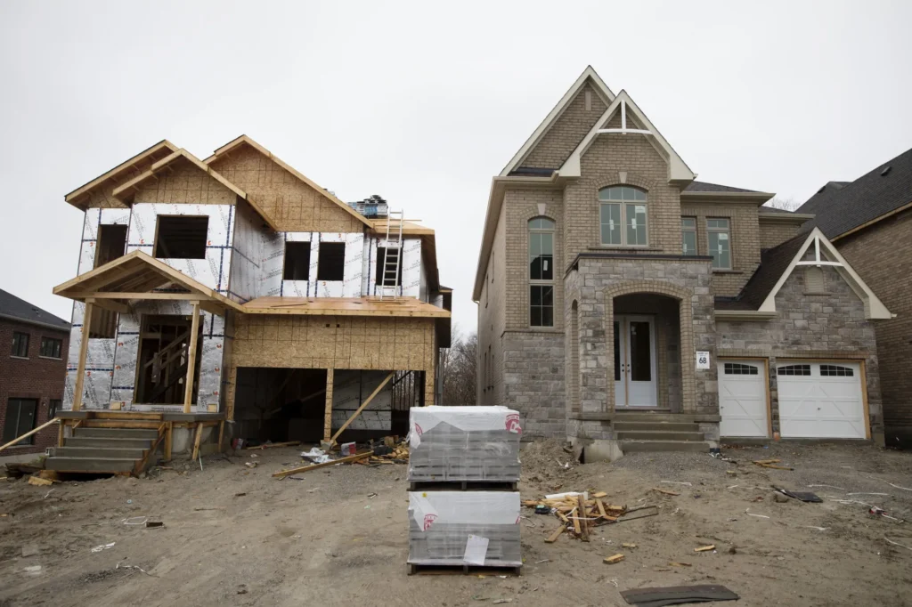 Side-by-side view of a house under construction and a completed modern brick home.
