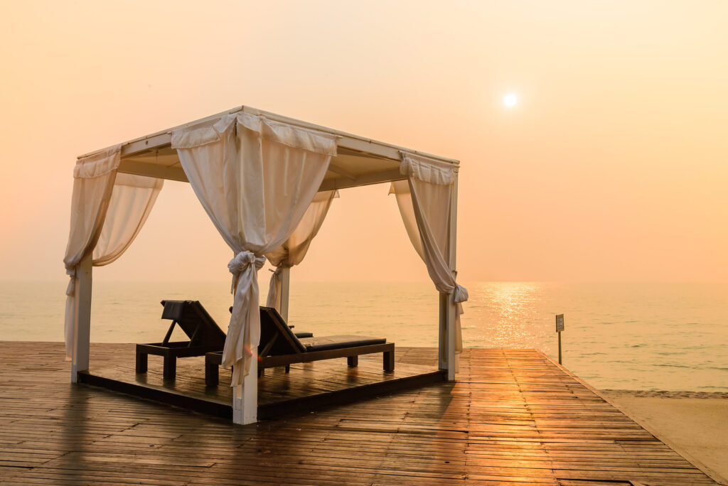 Daybed on sandy beach facing the sea