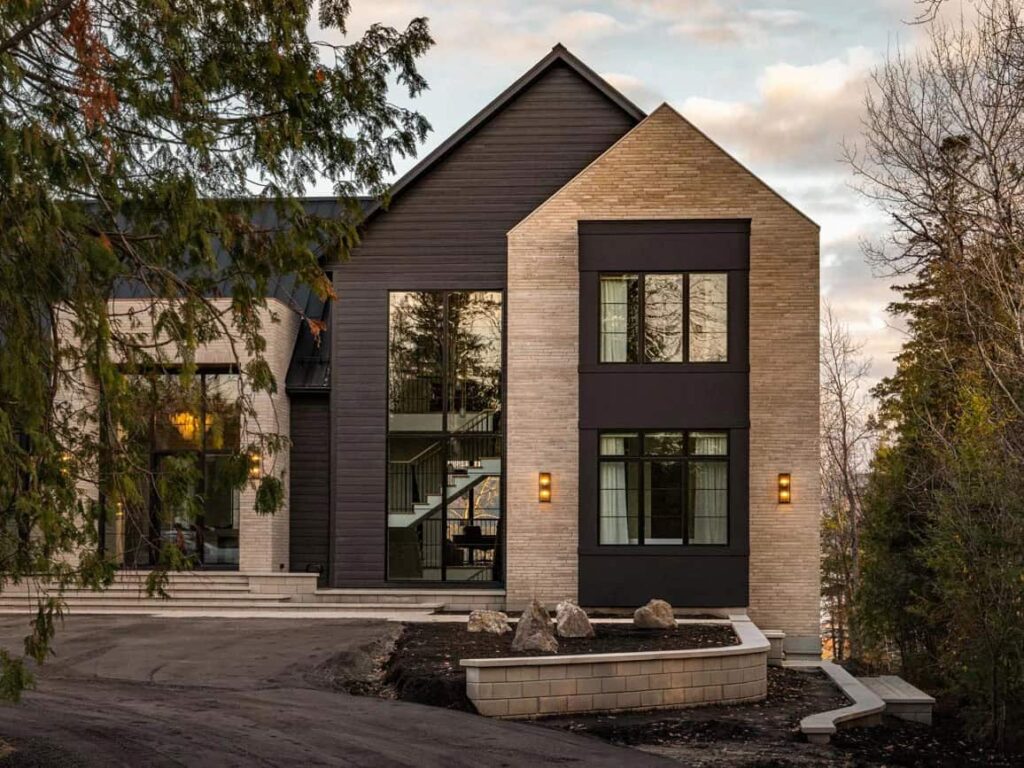 Modern custom-built two-story home with black-trim windows, white siding, landscaped front yard, and covered entry porch.