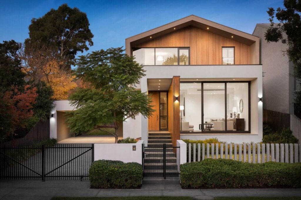 Modern custom-built two-story home with black-trim windows, white siding, landscaped front yard, and covered entry porch.