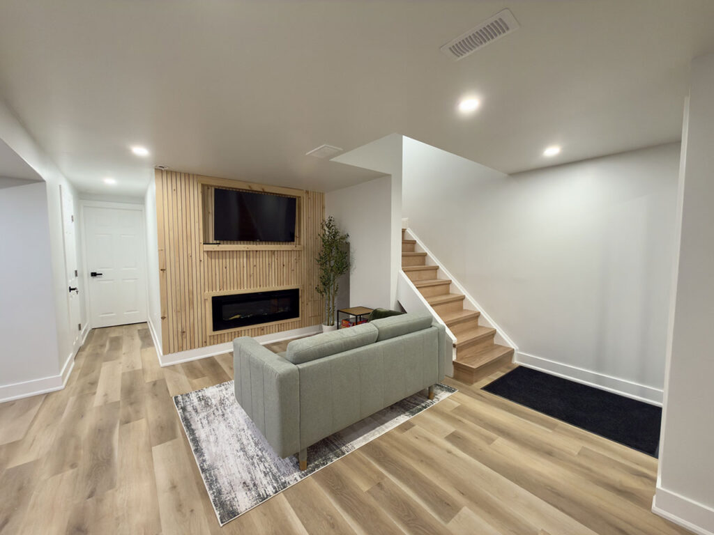 Finished basement staircase and hallway with hardwood flooring and modern railing in an Aurora, ON home by Jacko Contracting